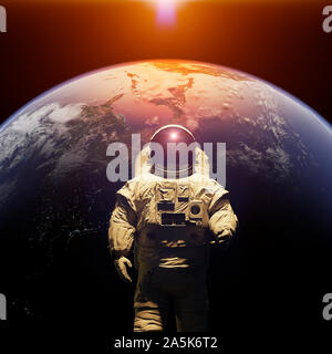 standing astronaut in front of planet Earth Stock Photo