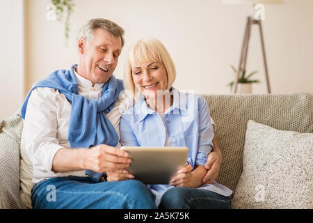 Surfing internet. Mature couple using digital tablet Stock Photo