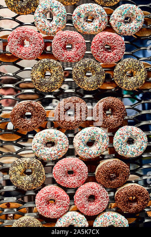 Colorful glazed donuts on a wire rack Stock Photo
