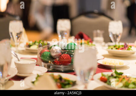 Christmas table setting with salads and ornament centerpiece Stock Photo