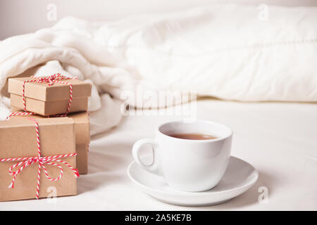 Cup of tea, Christmas gift boxes, knitted plaid on the white background. Stock Photo
