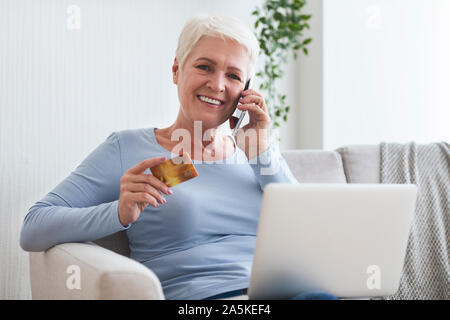 Modern old lady using online banking, recommending friends Stock Photo
