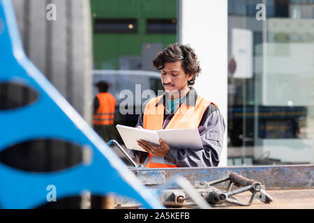 Male engineer on construction site writing in notebook Stock Photo