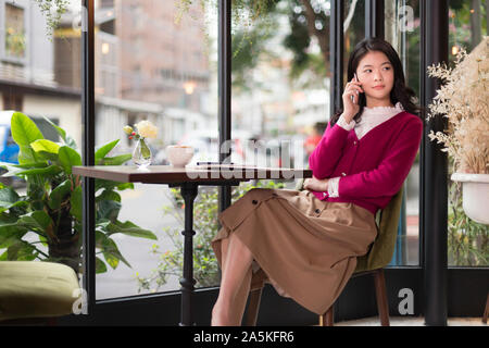 Woman talking on phone in cafe Stock Photo