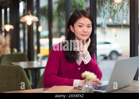 Woman working on laptop in cafe Stock Photo