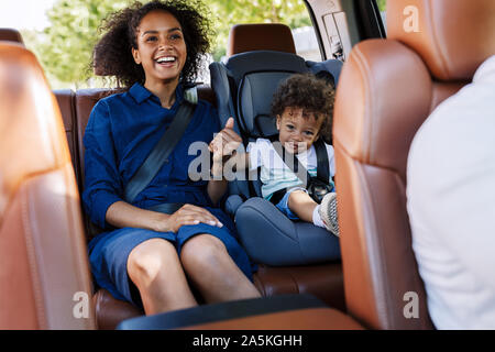Happy mother and her son sitting on a backseat while traveling in a car Stock Photo