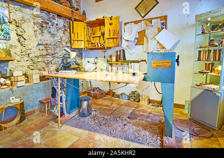 HALLSTATT, AUSTRIA - FEBRUARY 25, 2019: The woodworker workshop in souvenir store with a view on joiner machine, different carpentry tools and many cu Stock Photo