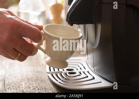 https://l450v.alamy.com/450v/2a5kj91/hand-puts-a-cup-in-the-coffee-machine-2a5kj91.jpg