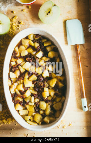 Photography series how to make an apples crumble , from the ingredients to the finish cake, rustic environment, apple pieces cut are cooked with sugar Stock Photo