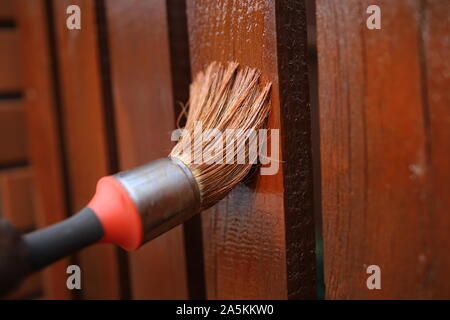 painting a wooden fence with a brush, brush on wall,brush on wooden background, Stock Photo
