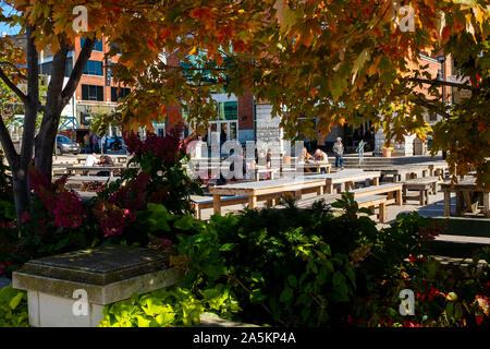 London, Canada - October 18, 2019. Lunch time patrons enjoy a sunny autumn by eating outside at a popular food market. Stock Photo