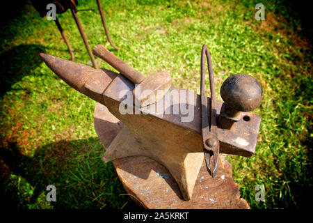 Hammer and pliers resting on  an anvil. Stock Photo