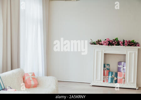 white sofa with a fireplace in the interior of a white room with windows Stock Photo