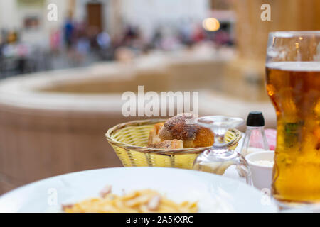 A bread basket of freshly baked rolls on a patio table in a piazza at Place Rossetti on the French Riviera in Nice, France. Stock Photo
