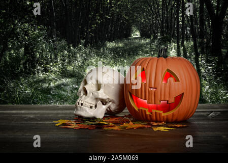 halloween pumpkin and skull in the evening on wood table Stock Photo
