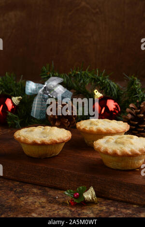 three mincemeat pies on wood cutting board Stock Photo