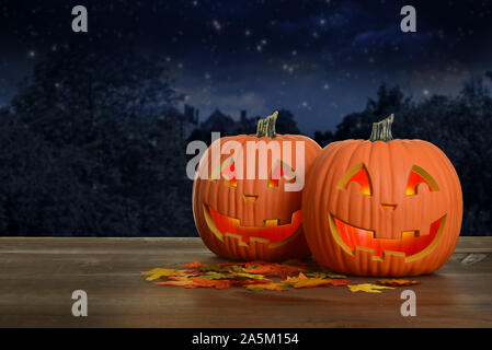 two halloween pumpkins at night glowing Stock Photo
