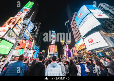 New York City, United States - Mar 31, 2019: Crowded people, car traffic transportation and billboards displaying advertisement in Times Square Stock Photo