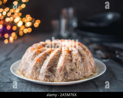 Homemade delicious jelly meat on festive Christmas table. Perfect jellied meat, aspic, galantine with carrot. Copy space for text. Stock Photo