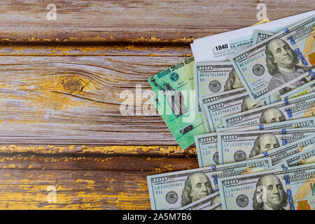 Stimulus economic tax return check and USA currency hundred US dollar bills 1040 U.S. Individual Income Tax Return Stock Photo