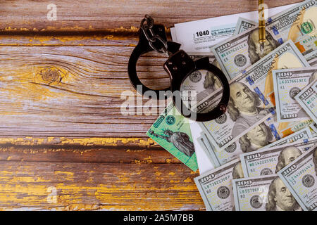 Tax form financial with handcuffs and currency US dollar banknotes Stock Photo