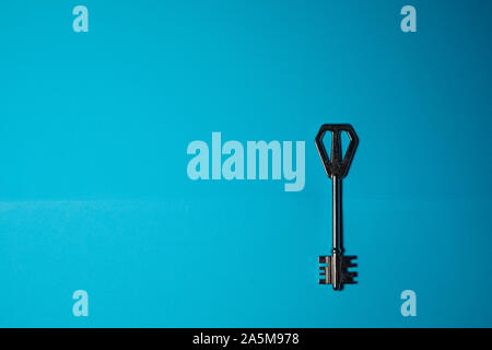 Key on blue background. Minimal creative style Stock Photo