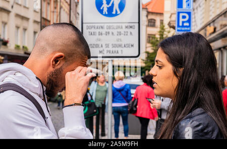Woman consoling upset friend on pavement, Prague, Czech Republic Stock Photo
