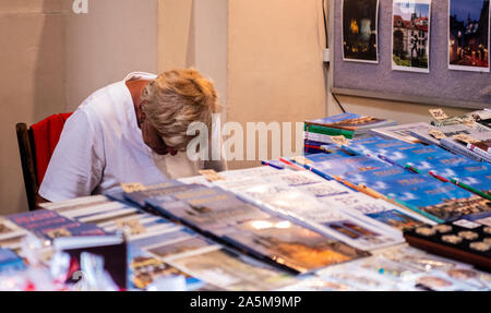 Woman selling travel guide books at stall, Old Town Square, Prague, Czech Republic Stock Photo