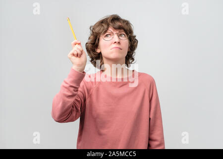 Young woman student holding finger with pencil up. Online education Stock Photo