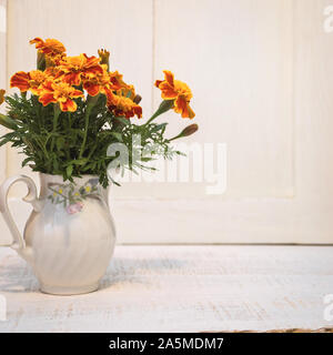 Beautiful orange flowers of Tagetes in ceramic vase. Concept of autumn flowers. Stock Photo
