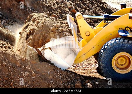 one yellow excavator excavating the ground Stock Photo