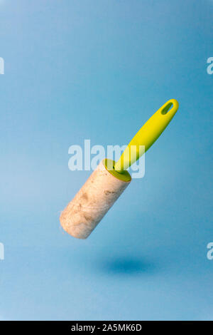 Lint roller (cleaning clothes roller) with trash on a blue background. Minimal concept. Stock Photo
