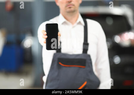 Male in working clothes showing gadget Stock Photo