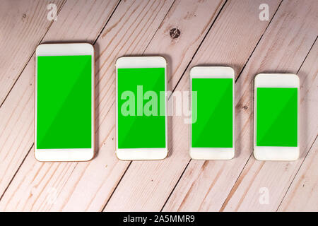 Cellphone on a wooden background with green screen Stock Photo
