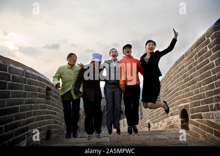 Group of woman jumping on the Great Wall of China. Stock Photo