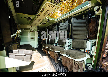 Interior view of empty multi-role armored military vehicle personnel carrier interior with chairs for infantry soldiers inside reconnaissance vehicle Stock Photo