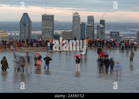 Blurred people on the Kondiaronk belvedere at Chalet Mont Royal in Parc Mont Royal with the skyscrapers of downtown Montreal beyond Stock Photo