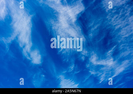 High white wispy cirrus cirro-stratus clouds in a blue Australian sky  sometimes called mare's tails indicate fine weather now but storms coming soon. Stock Photo