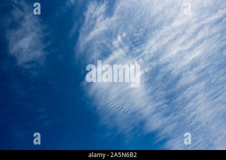 High white wispy cirrus cirro-stratus clouds in a blue Australian sky  sometimes called mare's tails indicate fine weather now but storms coming soon. Stock Photo