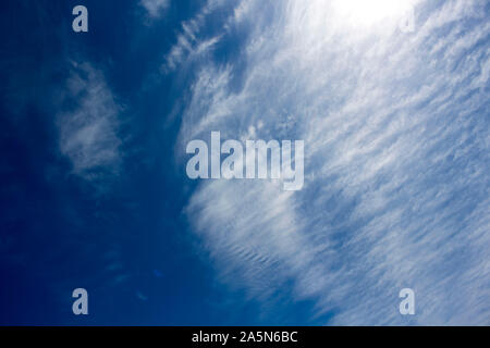 High white wispy cirrus cirro-stratus clouds in a blue Australian sky  sometimes called mare's tails indicate fine weather now but storms coming soon. Stock Photo