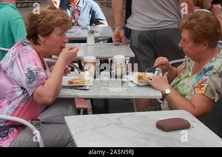 two old ladies are eating a slice of cake and sipping a melange in a cafe in Vienna Stock Photo