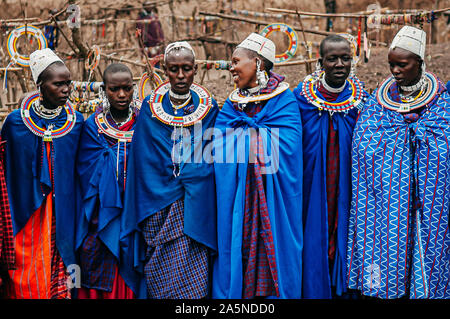 JUN 24, 2011 Serengeti, Tanzania - Group of African Masai or Maasai tribe woman in blue cloth wearing headpiece and stone beads ornaments. Ethnic grou Stock Photo