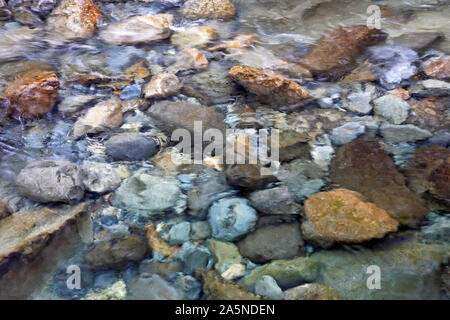 A background of stones in a clear flowing stream at the Fairy Pools, Isle of Skye, Scotland, United Kingdom, Europe. Stock Photo