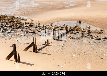 Decaying groynes on the beach at Llanfairfechan, North Wales Stock Photo