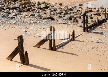Decaying groynes on the beach at Llanfairfechan, North Wales Stock Photo