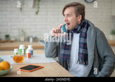 Man using inhalator while suffering from asthma Stock Photo