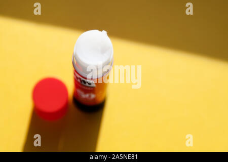 Umea, Norrland Sweden - October 2, 2019: glue stick and cork from the office seen from above. Everything on yellow background Stock Photo