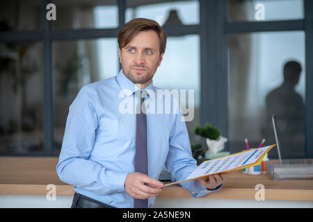 Blue-eyed young businessman feeling dizzy at work Stock Photo