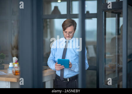 Businessman checking e-mail on tablet before going home Stock Photo