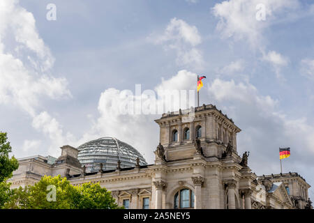 German flags waving on the Reichstag building in the historic center of Berlin, Germany, against a dramatic sky Stock Photo